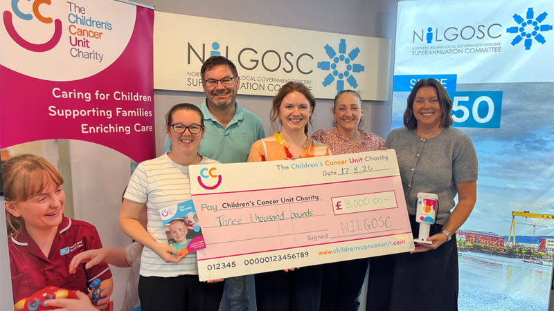 Select NILGOSC staff and rep from Charity smiling with presented cheque.